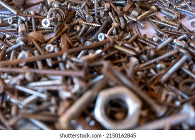 Pile of rusty nails and small hardware nuts, selective focus, nuts and bolts, rusty nail background, hardware concept