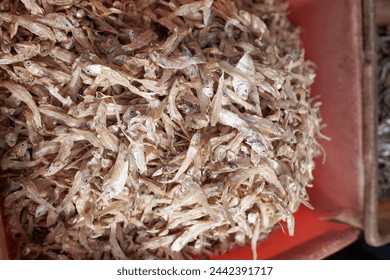 Pile of salted anchovies in a basket, at a traditional market.