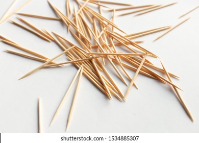 Pile of scattered toothpicks on white background