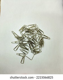 Pile Of Silver Paper Clips On The White Paper