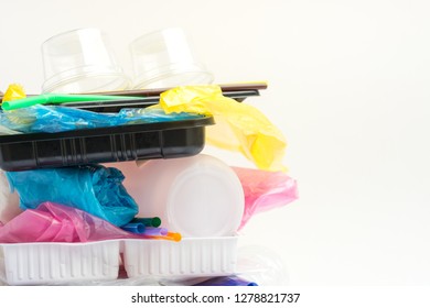 A Pile Of Single Use Plastic Garbage Including  Water Bottles, Drinking Straws, Food Packages And Carrier Bags On White Background With Copy Space. Pollution Concept.