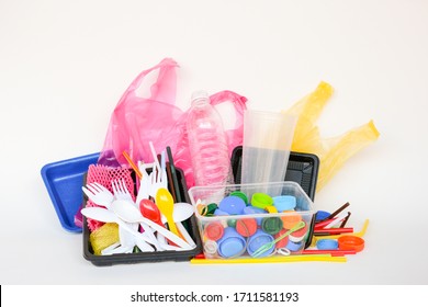 A Pile Of Single Use Plastic Trash Including  Water Bottles, Drinking Straws, Food Packages Fork, Spoon, Caps Cups And Carrier Bags On White Background. Pollution Concept.