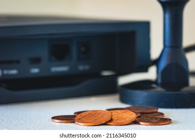 Pile Of Small Coins In Front Of Helium Hotspot Cryptocurrency Miner Device. Association Of Just Making Pennies From Blockchain Activities.