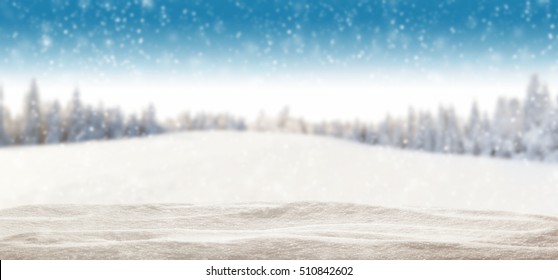 Pile of snow with blur winter panorama. Landscape with spruce trees, blue sky with sun light on background - Shutterstock ID 510842602