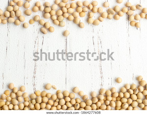A pile of\
soybeans, divided into two rows on white wooden table. Soybean is a\
leguminous plant native to Asia, widely cultivated for its edible\
seeds. with copy space for your\
text