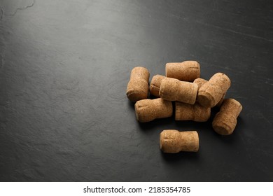 Pile Of Sparkling Wine Corks On Black Table. Space For Text