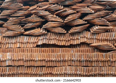 Pile or stack of traditional glazed clay roof tiles used for covering rooftop of Thai buddhist temples restoration. Typical of Asia construction, Selective Focus.