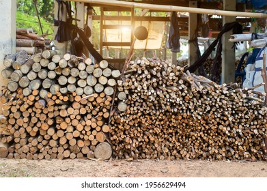 A pile of stacked firewood, prepared for heating the house. Firewood harvested for heating in winter. Chopped firewood on a stack. Firewood stacked and prepared for winter Pile of wood logs