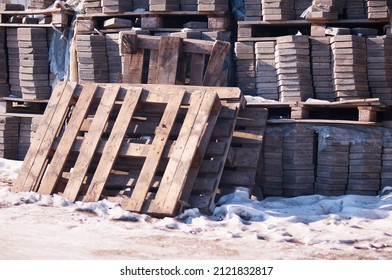 Pile Of Stacked Pallets With Paving Stones. Outdoor Storage Of Paving Slabs In Winter. Used Tiles Are Waiting To Be Reused.