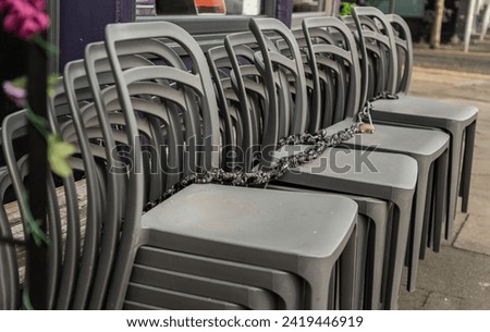 Pile of stacking silver gray plastic chairs are beside of The cafe terrace at sunny day. Detailed of pattern stack plastic chairs, Space for text, Selective focus.