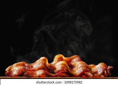 Pile Of Steaming Hot Freshly Cooked Bacon With Room For Text In Black Background