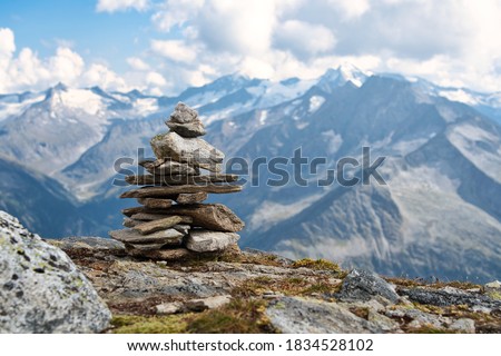 A pile of stones (also called cairn, Steinmännchen or Steinmandl) in the austrian alps, used as a hiking marker. They are also found in buddhist temples and will be used as zen stones for meditation. 