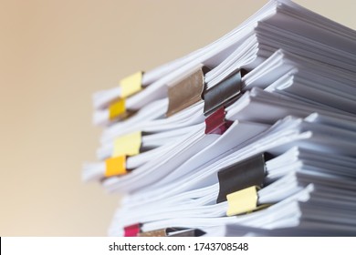 Pile of student homework that assigned to student to be completed outside class on teacher desk separated by colored paper clips. Document stack arranged by paperclip. Business and education concept. - Shutterstock ID 1743708548
