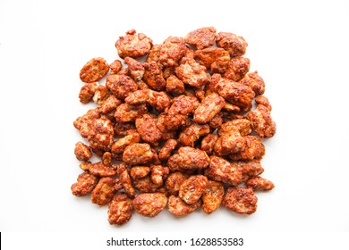 A pile of sugar roasted pecan nuts (caramelized, praline nuts) on a white background, top view