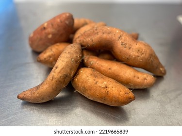 Pile Of Sweet Potatoes On A Stainless Steel Worktop.