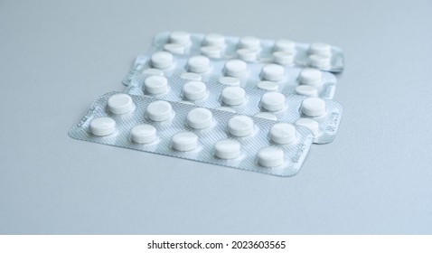 Pile of tablets in blister packs. Package of white pills. Pharmacy and medicine concept.