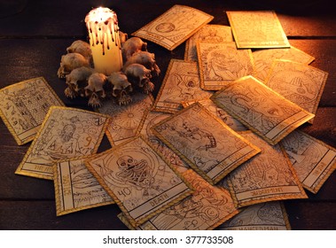 Pile Of The Tarot Cards In Candle Light. Halloween And Magic Still Life, Fortune Telling Seance Or Black Magic Ritual With Mysterious Occult And Esoteric Symbols, Divination Rite 