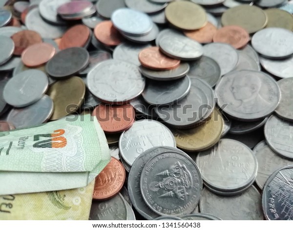 A pile of Thai coins and Thai banknote, selective focus and blurred photo for business and finance background.