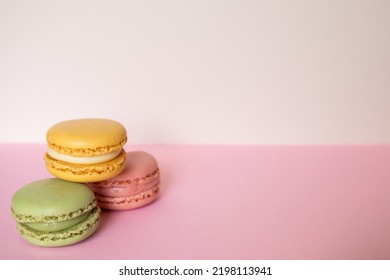 Pile Of Three Macaroons In Green, Pink And Blue Color, On A Pink Background. Concept Of Sweet Temptation, Caprice. Copy Space.