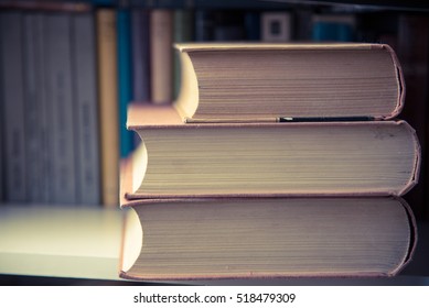 Pile Of Three Old Big Books On Shelf In Library