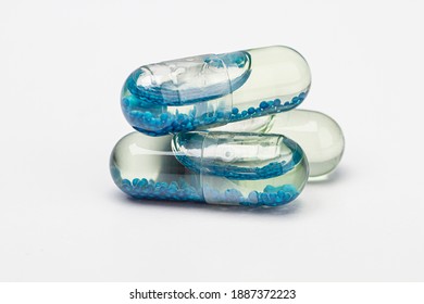 Pile Of Transparent Pill Containing Clear Liquid With Blue Beads