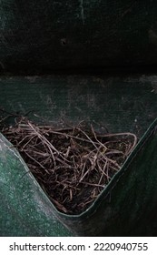 A Pile Of Twigs In A Green Wall Planter Bag