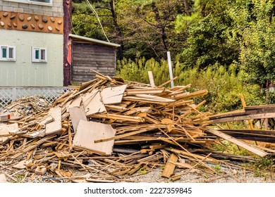 Pile Of Used Broken Lumber And Sheetrock Stacked In Graveled Drive.