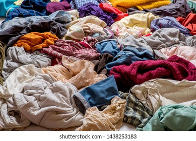 pile of used clothes on a light background. Second hand for recycling - Shutterstock ID 1438253183