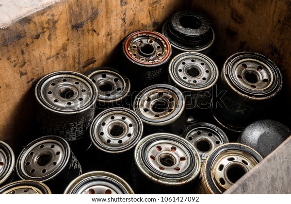 Pile of used oil filter of a car\
engine. Closeup picture of old oil filters for automobile. Picture\
of motor oil as product of oil refining\
industry.