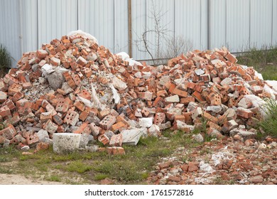 A Pile Of Used Red Bricks In The Yard.