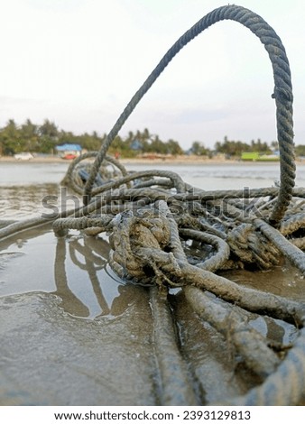 a pile of used rope on top of a puddle of water.