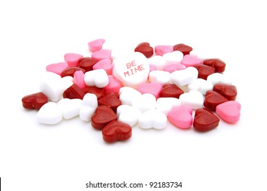 Pile of Valentines Day heart-shaped candies with "Be Mine" conversation heart