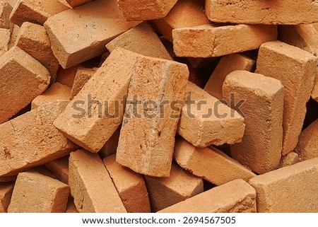 Pile of various colored clay bricks for house wall construction building materials background texture industrial and masonry concept
