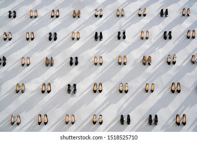 Pile Of Various Female Shoes Over White Wall