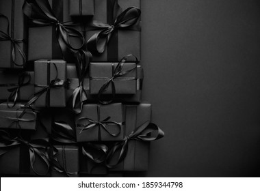 A pile various size black boxed gifts placed on stack. Christmas concept.