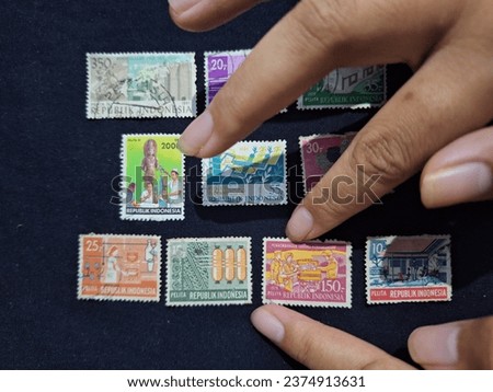 A pile of vintage old postage stamps collection issued by the Indonesian postal service, collected by a philatelist (stamp collector)