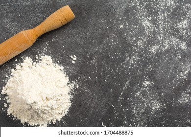 Pile Of Wheat Flour And A Rolling Pin On A Messy Granite Kitchen Counter