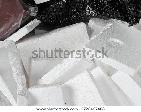 Pile of white expanded polystyrene (EPS) foam blocks and black bubble wrap