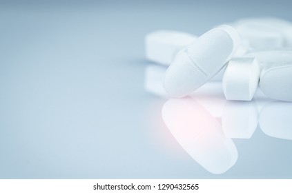 Pile Of White Oblong Tablets Pills On Gradient Background. Pharmaceutical Industry. Pharmacy Product. Global Healthcare. Drug In Pharmacy Drugstore Or Hospital. Drug Use In Pregnancy And Lactation.