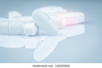 Pile Of White Oblong Tablets Pills On Gradient Background. Pharmaceutical Industry. Pharmacy Product. Global Healthcare. Drug In Pharmacy Drugstore Or Hospital. Drug Use In Pregnancy And Lactation.