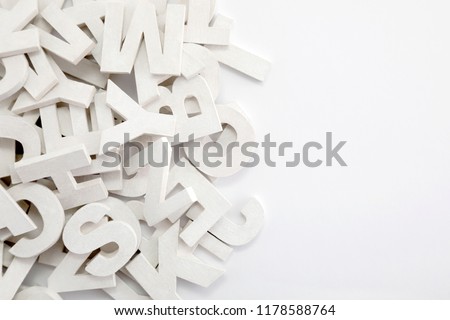 Pile of white painted wooden letters. Typography background composition. 