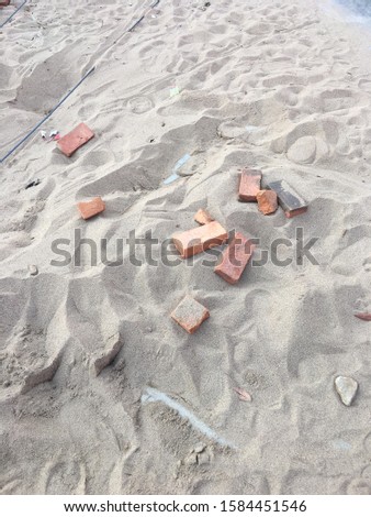 A pile of white sand with bricks, steel and wood inside