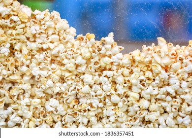 Pile Of White Yellow Fried Popcorn In The Popcorn Machine At The Movie Theater.Sweet And Salty Crunchy Snack For The Film.Delicious Unhealthy Food.