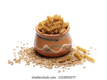 Pile wholemeal, uncooked integral pasta spirali and spelt grain isolated on white 