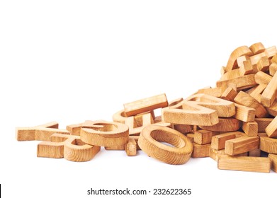 Pile Of Wooden Block Letters Isolated Over The White Background As A Typography Background Composition