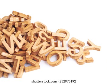 Pile Of Wooden Block Letters Isolated Over The White Background As A Typography Background Composition