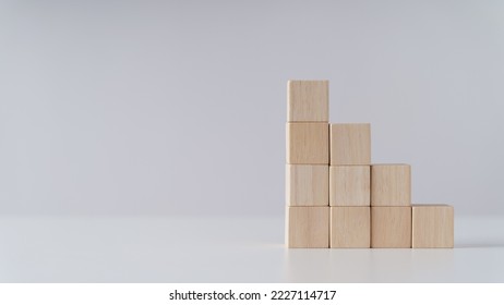 Pile of wooden cube block stack as stair step on the table. Success, climbing to the top, Progression, business growth concept.