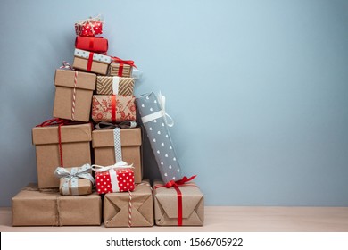 pile of wrapped christmas  gifts on blue background with copy space