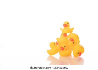 Pile Of Yellow Rubber Ducks Isolated On White Background. Ducklings Leader On Top, Bath Baby Toys. Struggle For Leadership, Career Ladder, Seizure Of Power, Dog-Eat-Dog World Concept. Copy Space