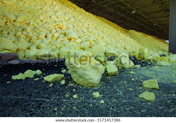Pile of Yellow sulfur on sulfuric acid factory\
warehouse and railway terminal. Oil refinery plant. Close-up of\
sulfur heap. (Sulphur).